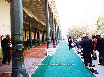 Muslims take off their shoes in front of the Prayer Hall